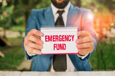 Person holding an "emergency fund" sign.